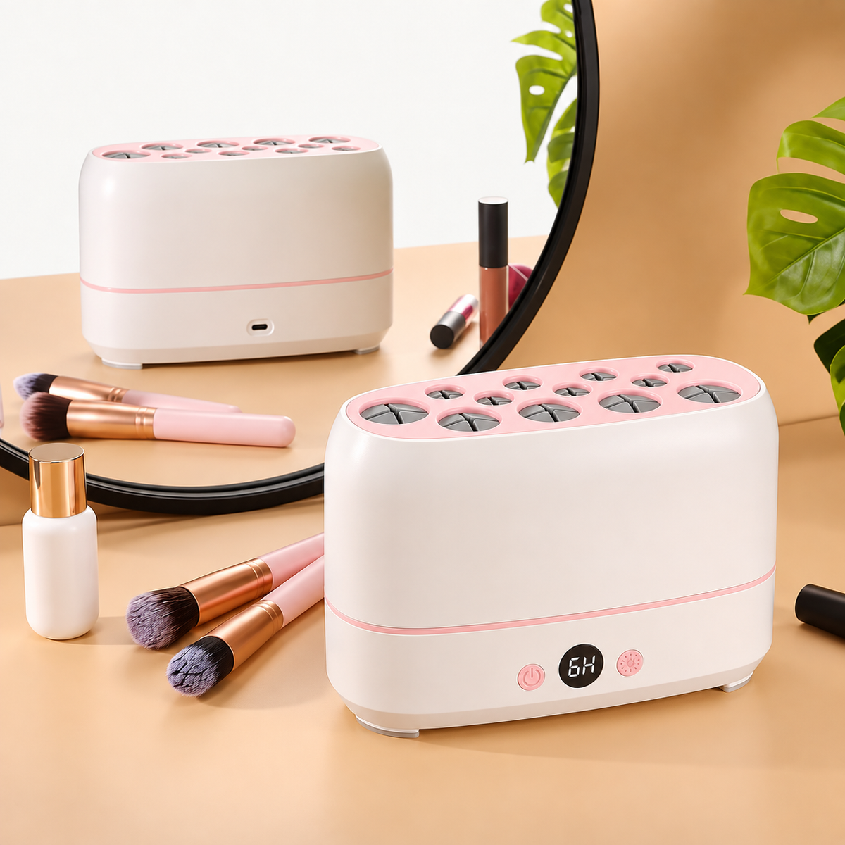 Secador de brochas blanco y rosa sobre un tocador, junto a brochas y cosméticos, con su conexión USB reflejada en el espejo.